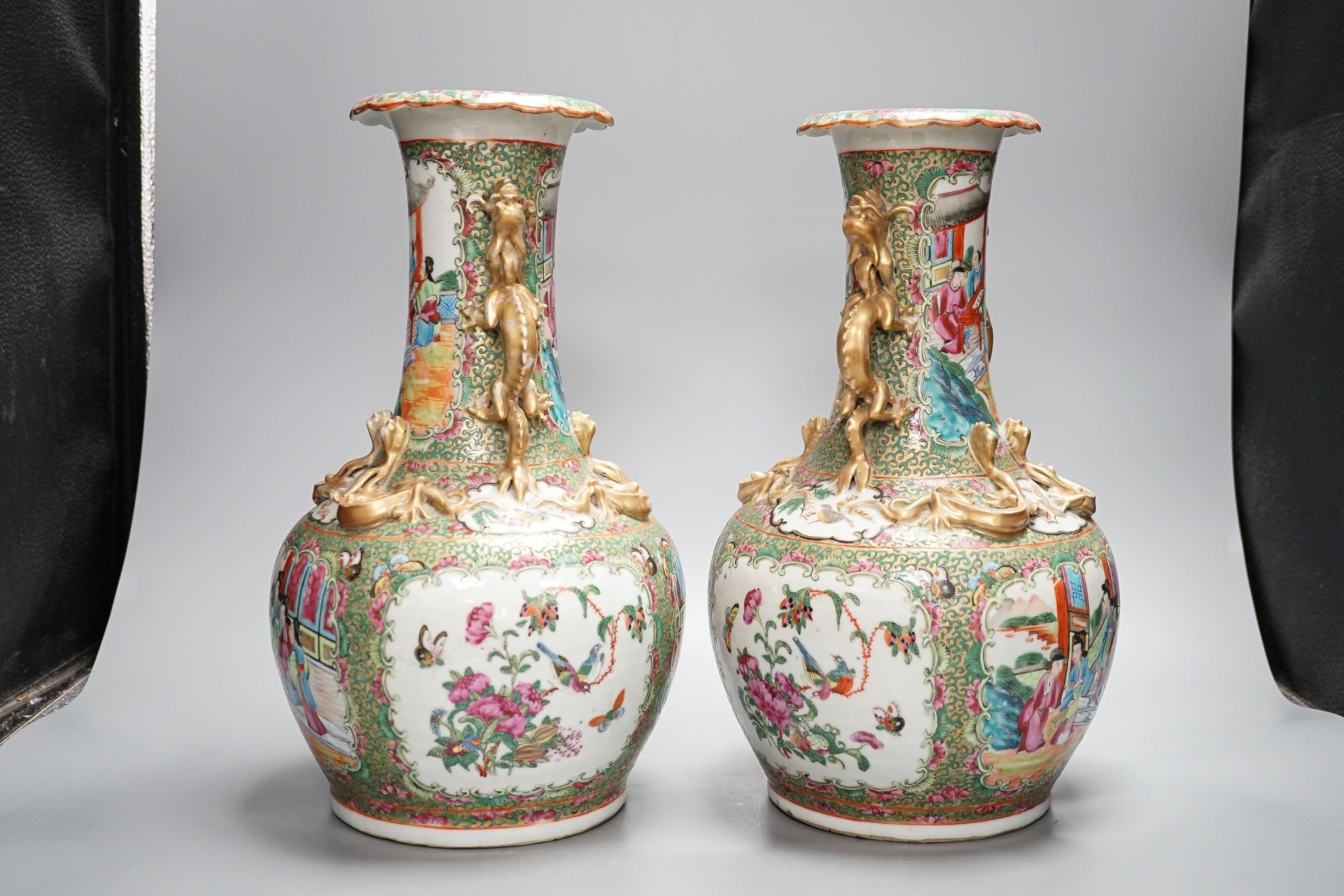 A pair of late 19th century Chinese famille rose vases, decorated with figures, birds and butterflies, twin lion dog handles, height 35cm